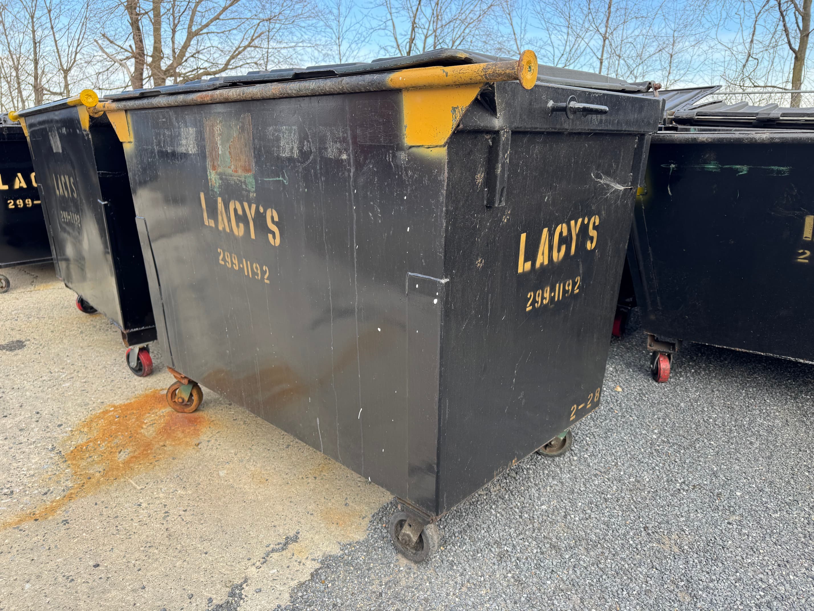 A black 2-yard rear-load dumpster