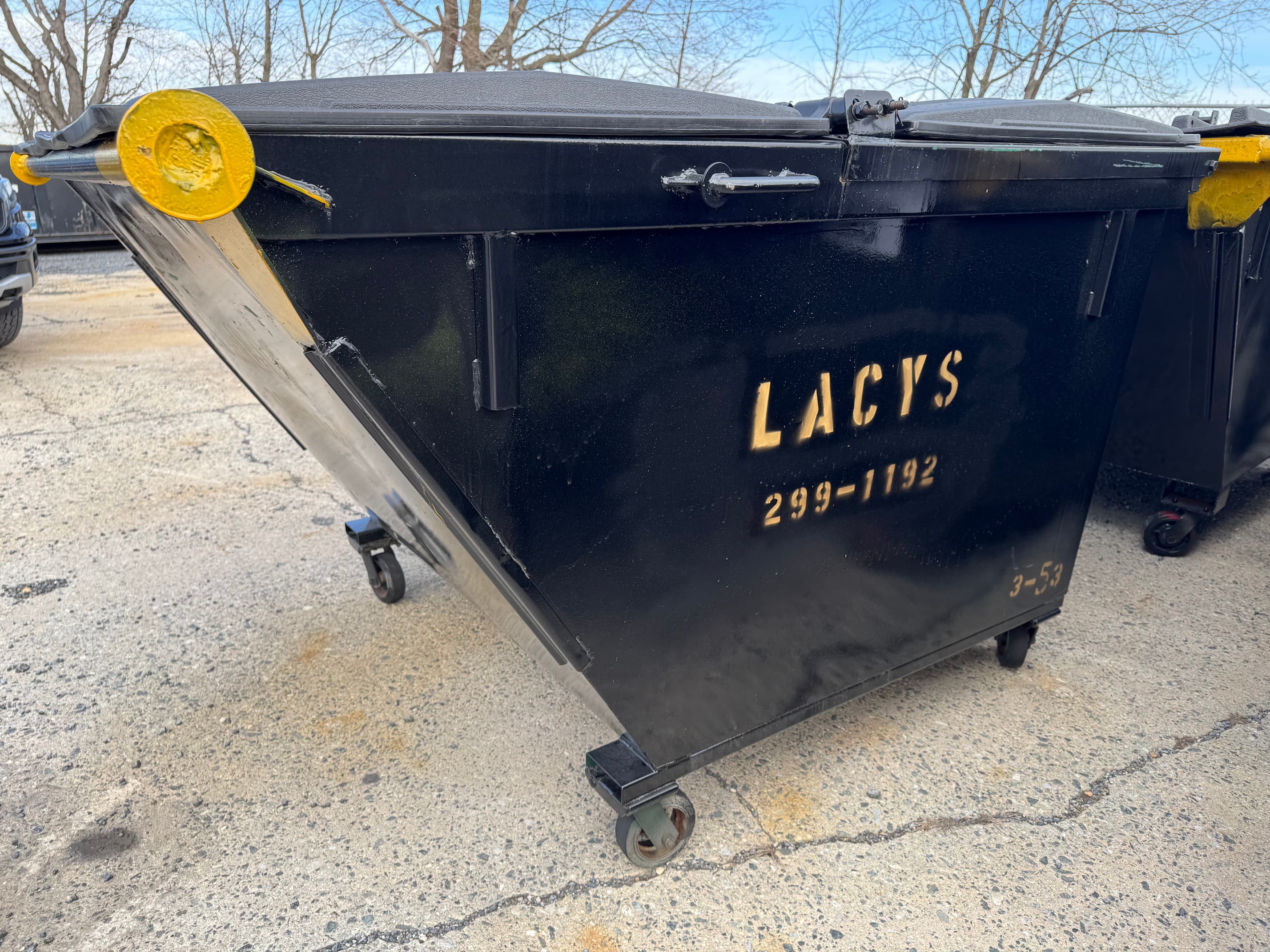 A black 3-yard rear-load dumpster