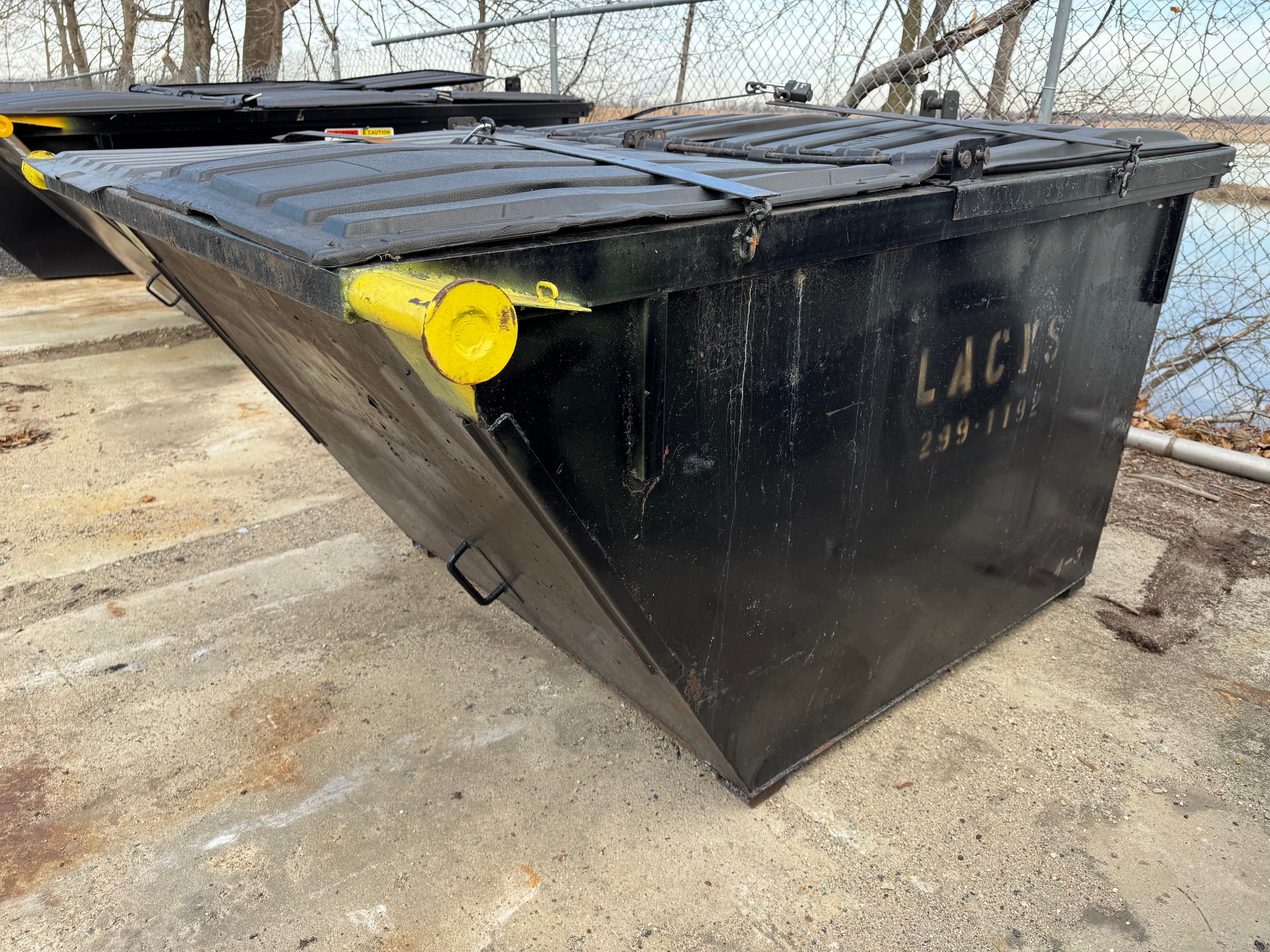 A black 4-yard rear-load dumpster