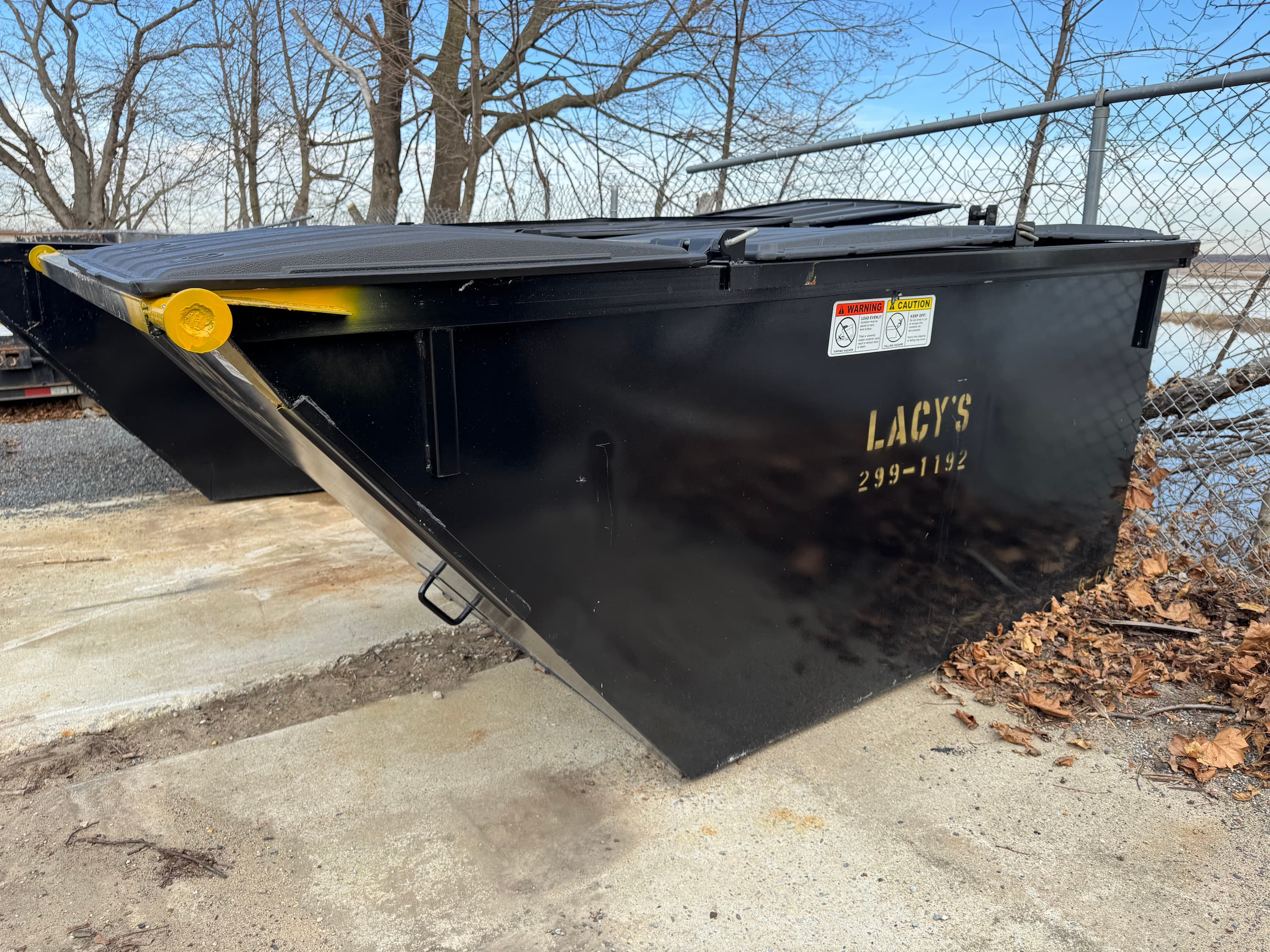 A black 6-yard rear-load dumpster
