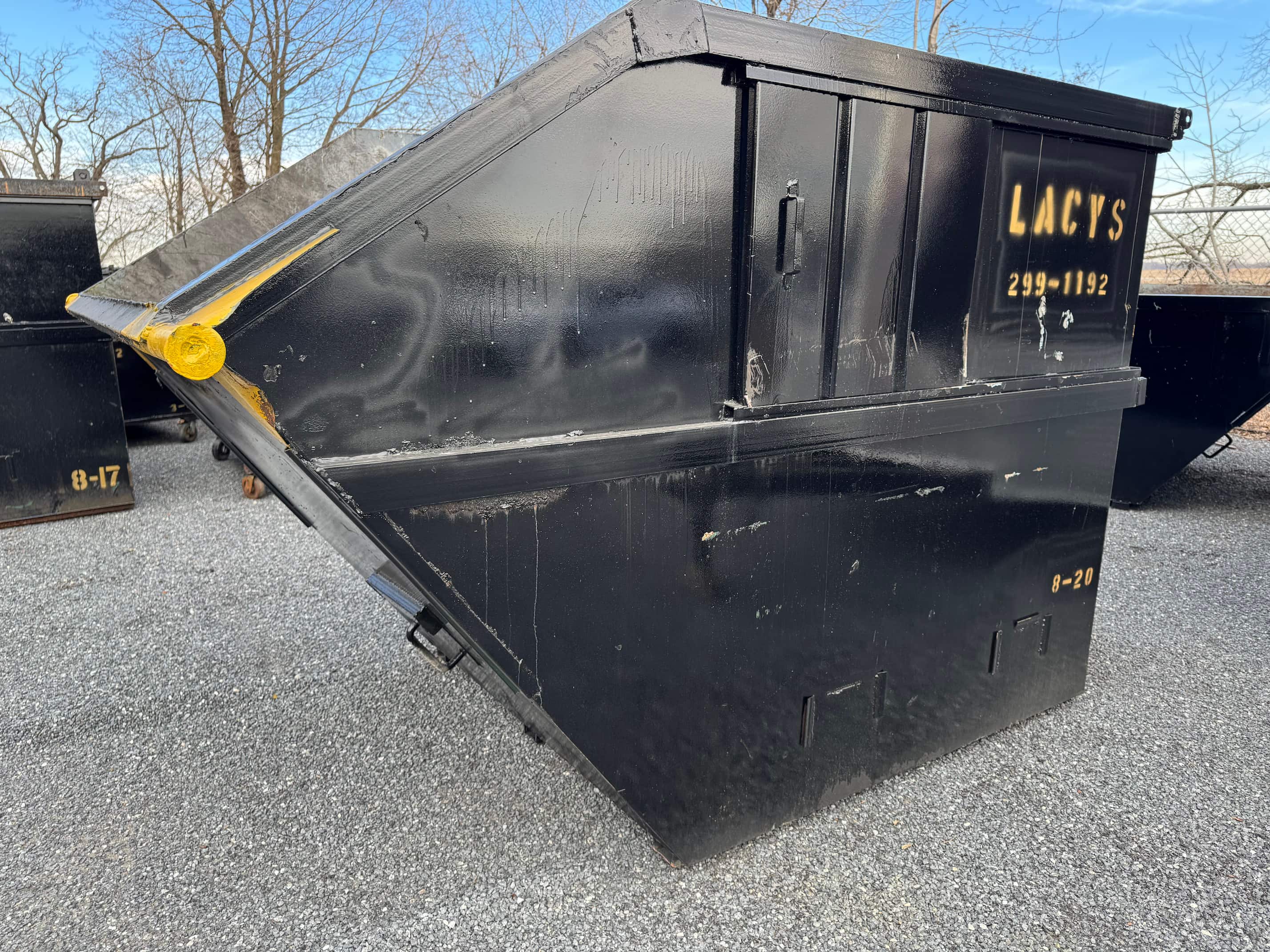 A black 8-yard rear-load dumpster