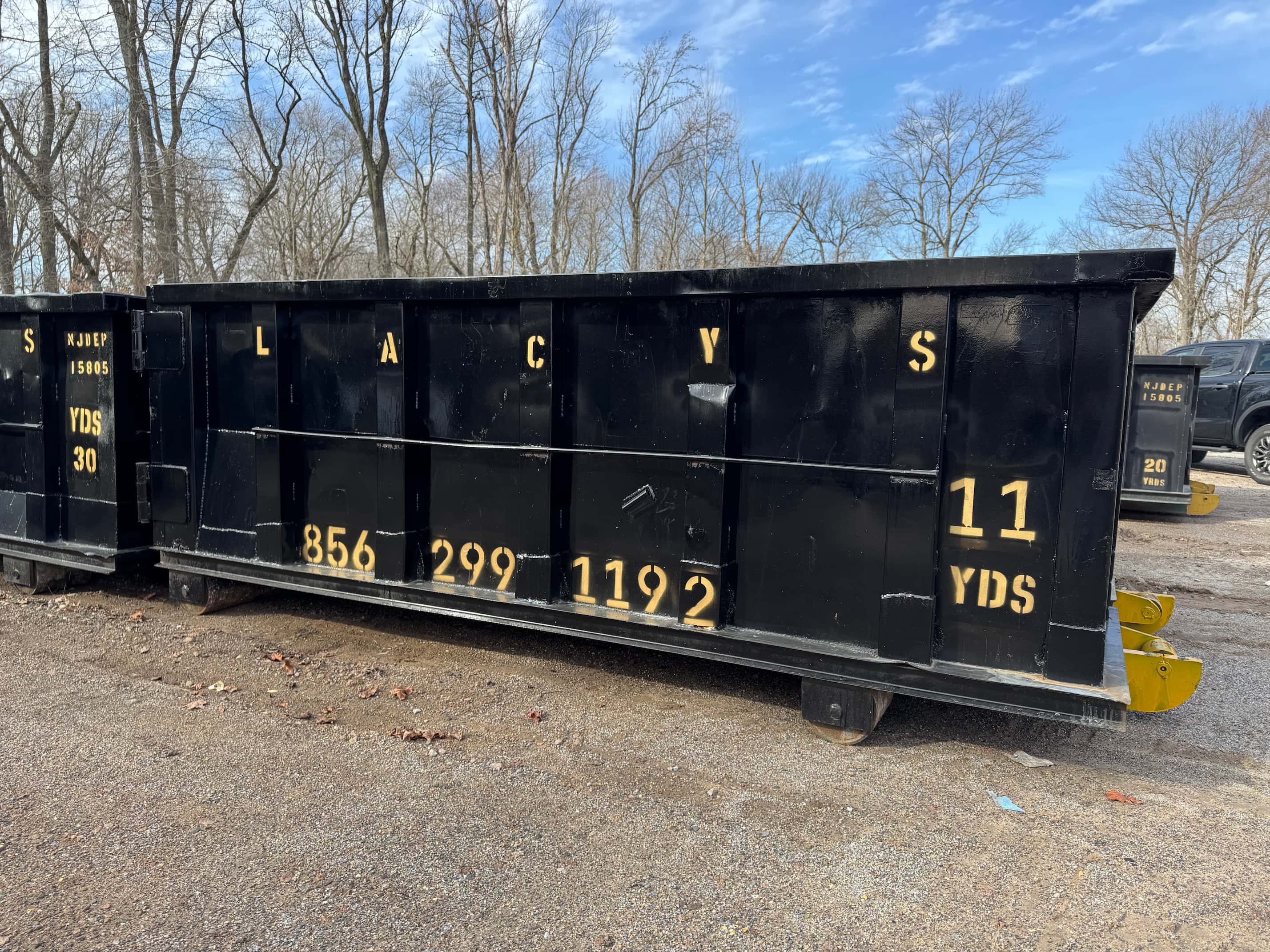 A black 11-yard roll-off dumpster